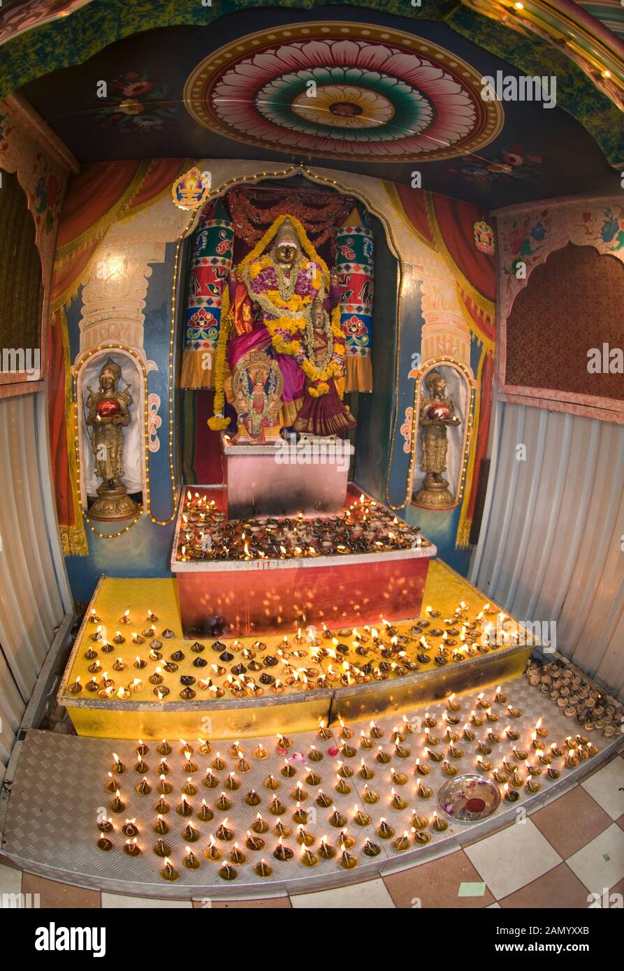 Kerzen in Fach an der Basis iof Gottheit mit Girlanden am Schrein von Deepavali Zeremonie, Sri Veeramakaliamman Tempel, Little India, Singapur Stockfoto