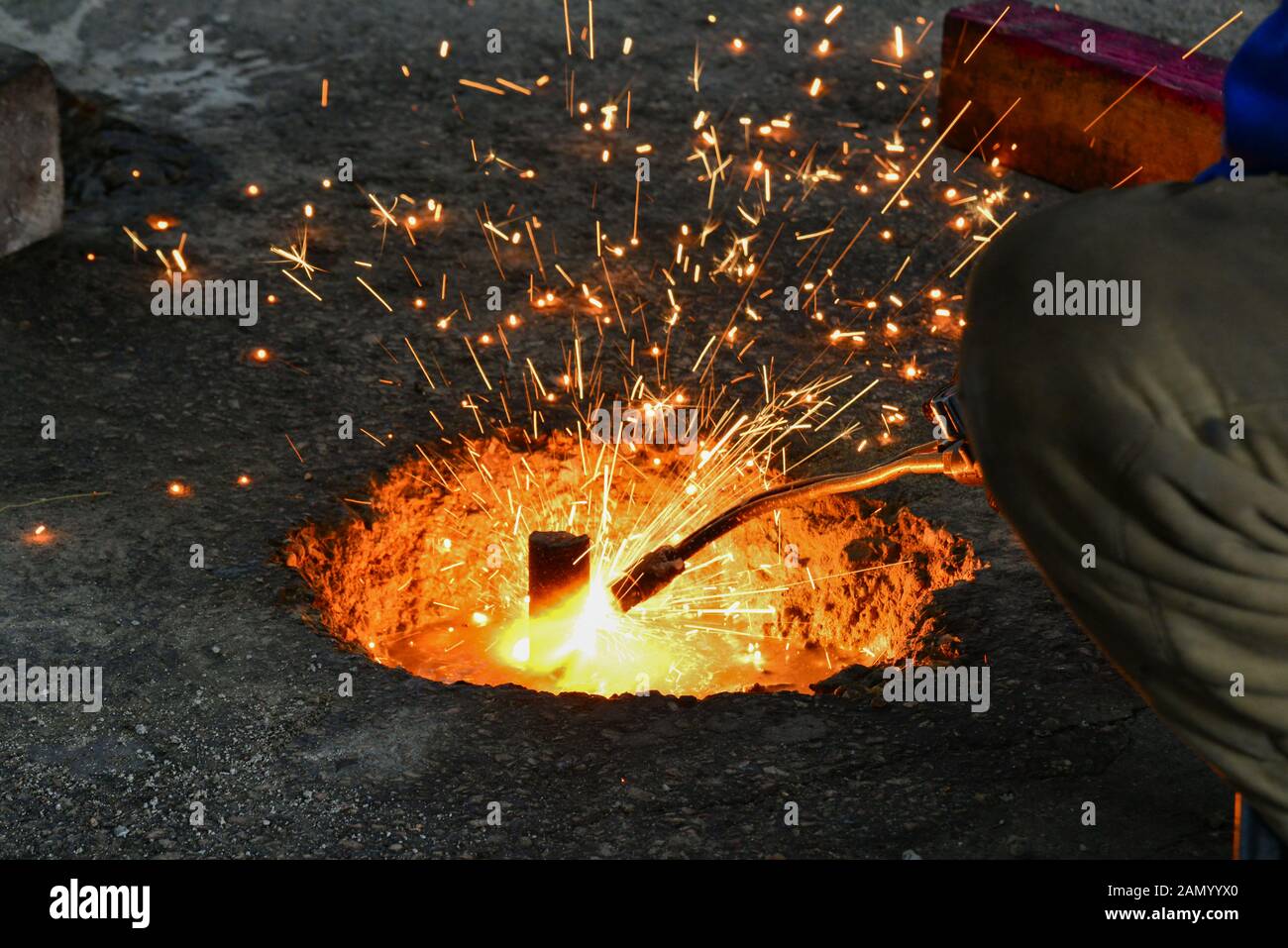 Ein gas Cutter in Produktion, ein Schweißgerät keine unnötigen metallischen Rückstände mit einem gas Cutter, Funken fliegen in verschiedene Richtungen. Stockfoto