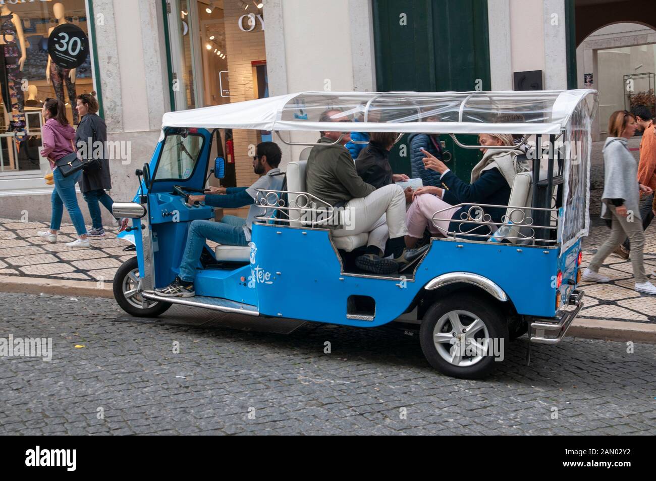 Tuktuk-Fahrer, die Touristen Besichtigungstouren in Lissabon, Portugal, anbieten Stockfoto