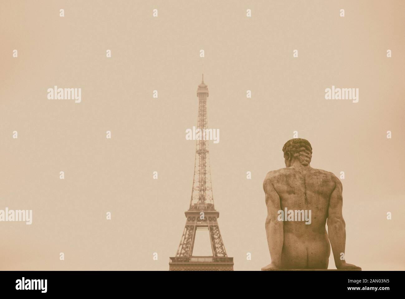 Eine Statue des Mannes mit dem Eiffelturm im Hintergrund. Stockfoto