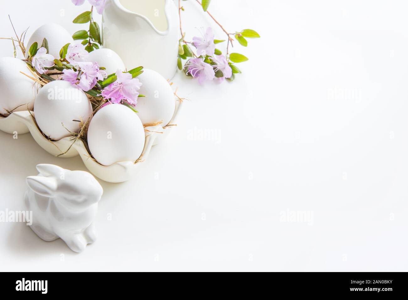 Bio-weiße Hühnereier mit frischen Frühlingsblumen auf Weiß. Ostern. Nahaufnahme Stockfoto