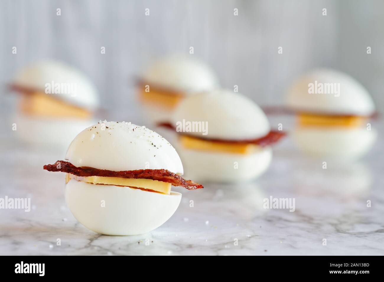 Keto BLT Sandwich, Ei oder ei Brötchen Snack für die ketogenic Diät Plan. Gekochte Eier mit der Türkei Speck und Cheddar Käse. Selektiver Fokus mit unscharfen Ba Stockfoto