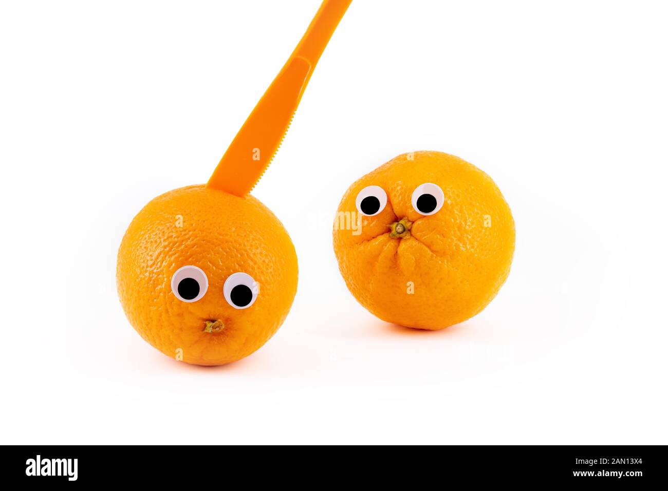 Zwei Orangen mit wackligen Augen, einer von einem Messer ermordet. Lustige PIC Stockfoto
