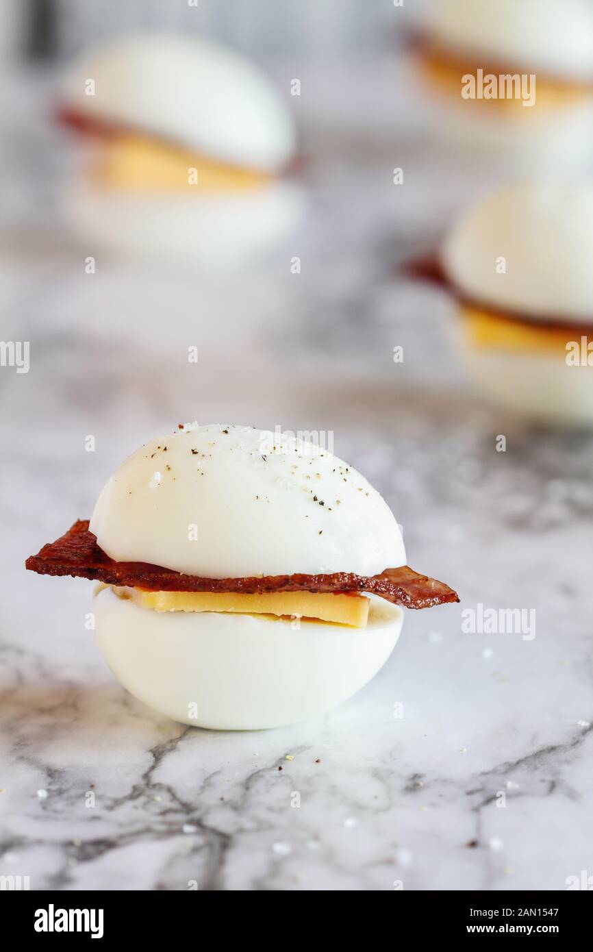 Keto BLT Sandwich, Ei oder ei Brötchen Snack für die ketogenic Diät Plan. Gekochte Eier mit der Türkei Speck und Cheddar Käse. Selektiver Fokus mit unscharfen Ba Stockfoto