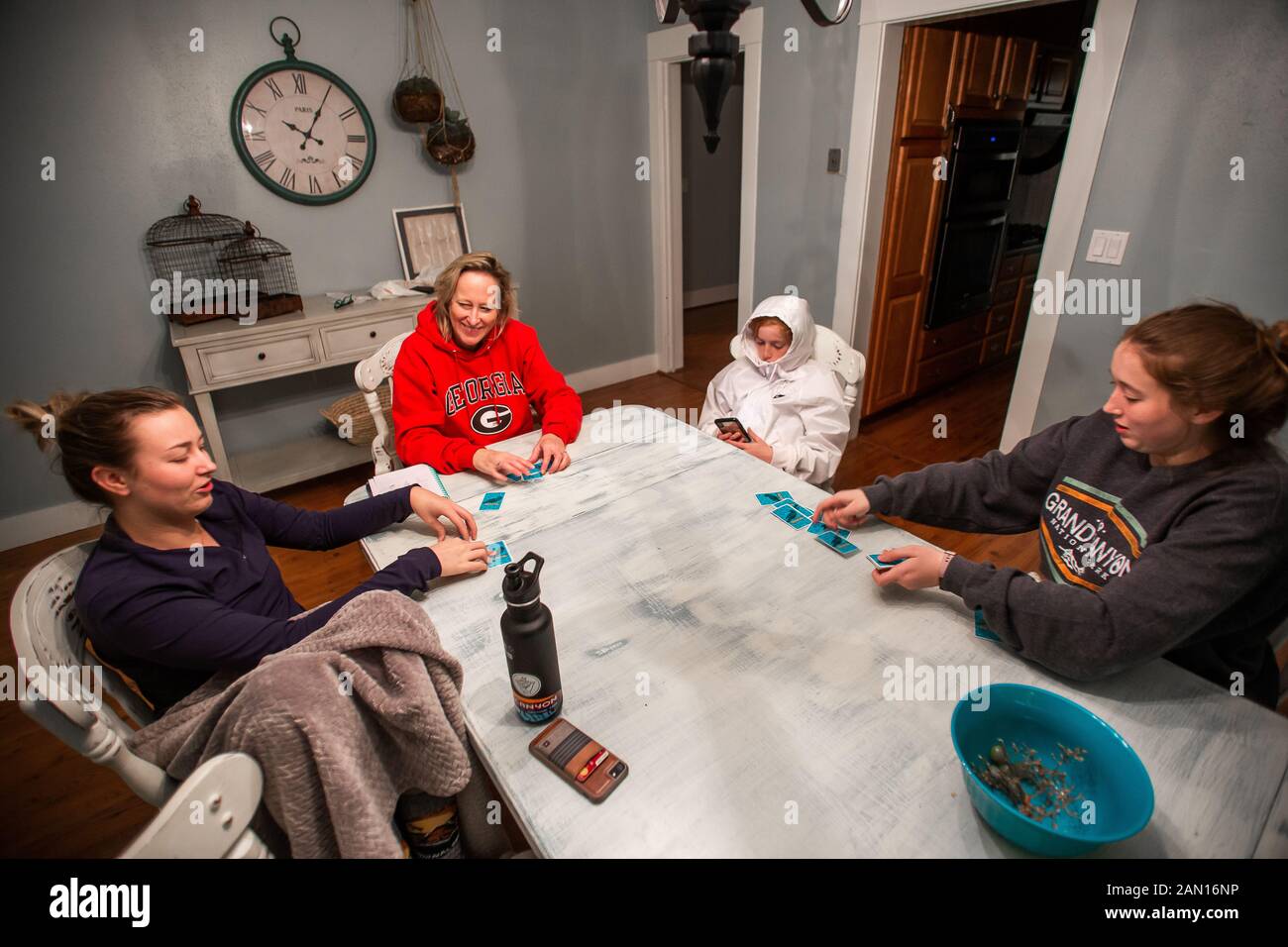 Familie, die Karten um den Esstisch spielt. Stockfoto