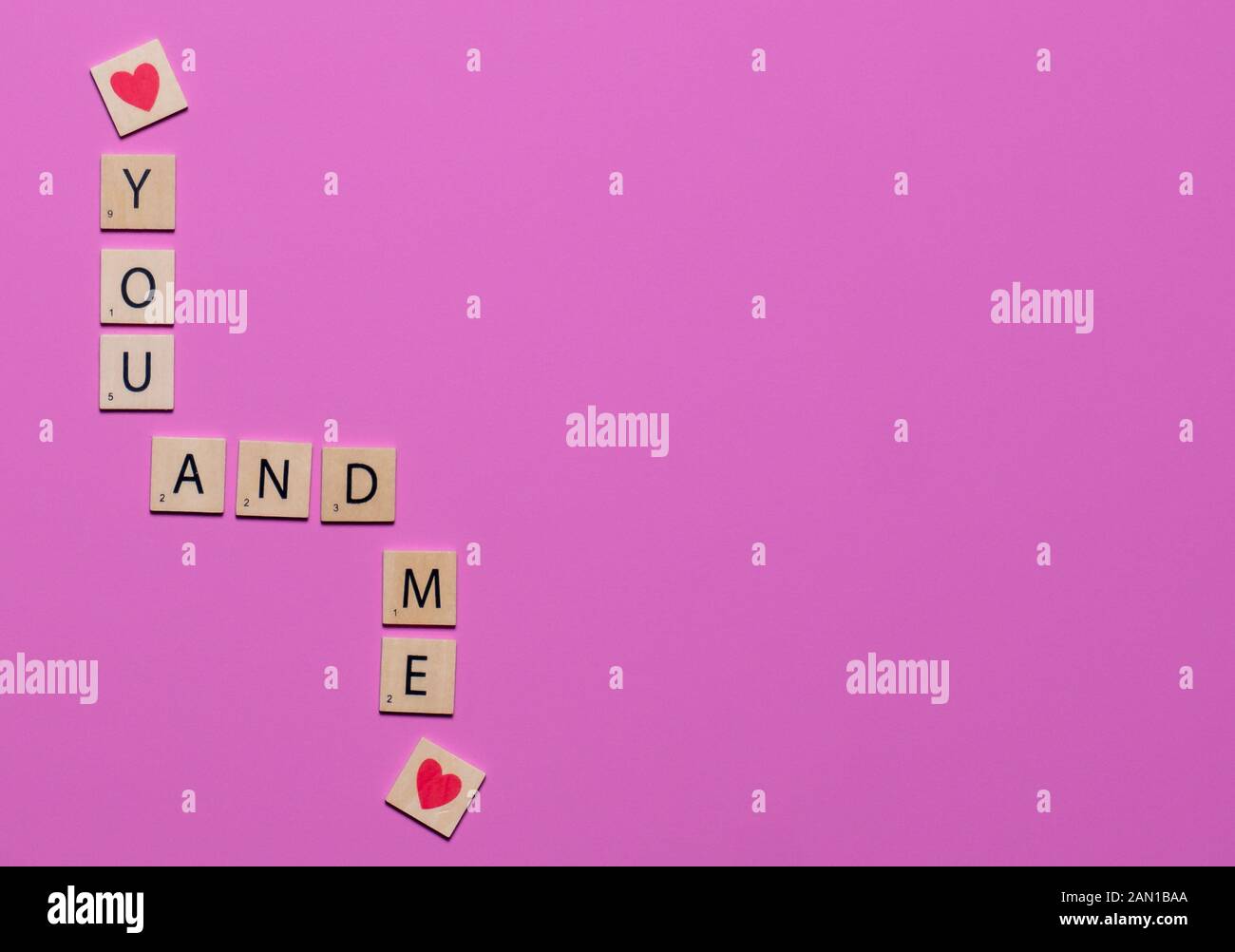 Bunte Du und Ich spiel Fliesen mit Herzen auf einem rosa Hintergrund Liebe zu feiern Stockfoto