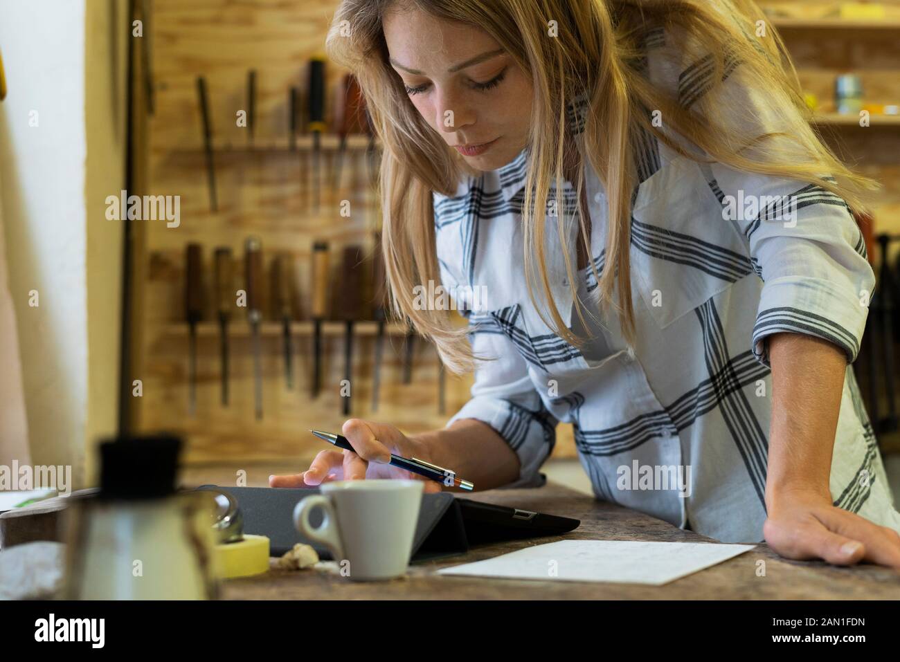 Frau mit digitalen Tablet in Werkstatt Stockfoto