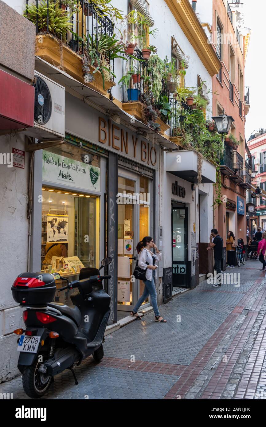 Grünen Balkone über eine Reihe von Geschäften in der schmalen Calle Regina in Sevilla Stockfoto