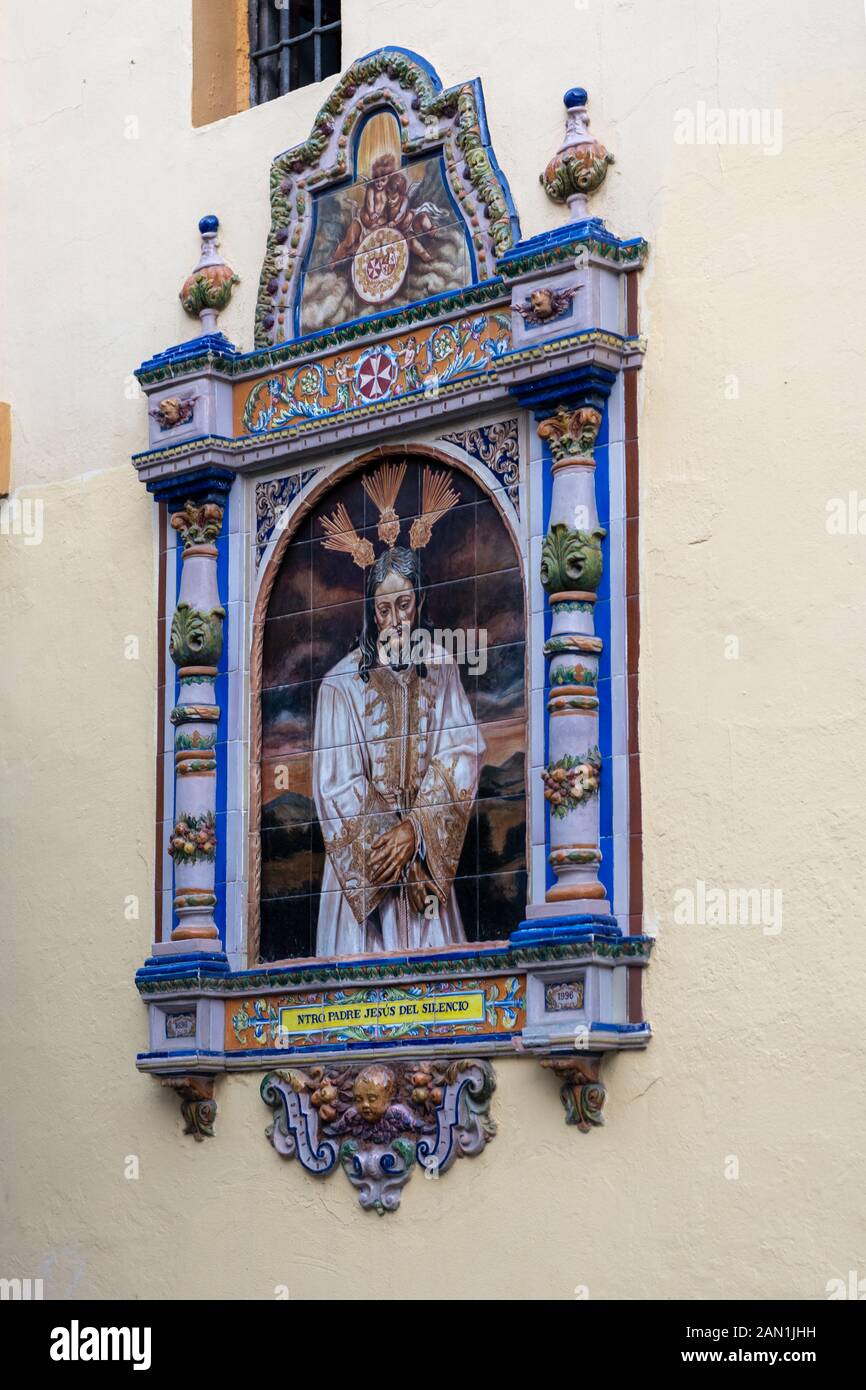 Eine traditionelle Fliesen- Gedenktafel an der Wand des 18. Jahrhunderts Iglesia de San Juan de La Palma in der Calle Feria de Sevilla, Sevilla. Stockfoto