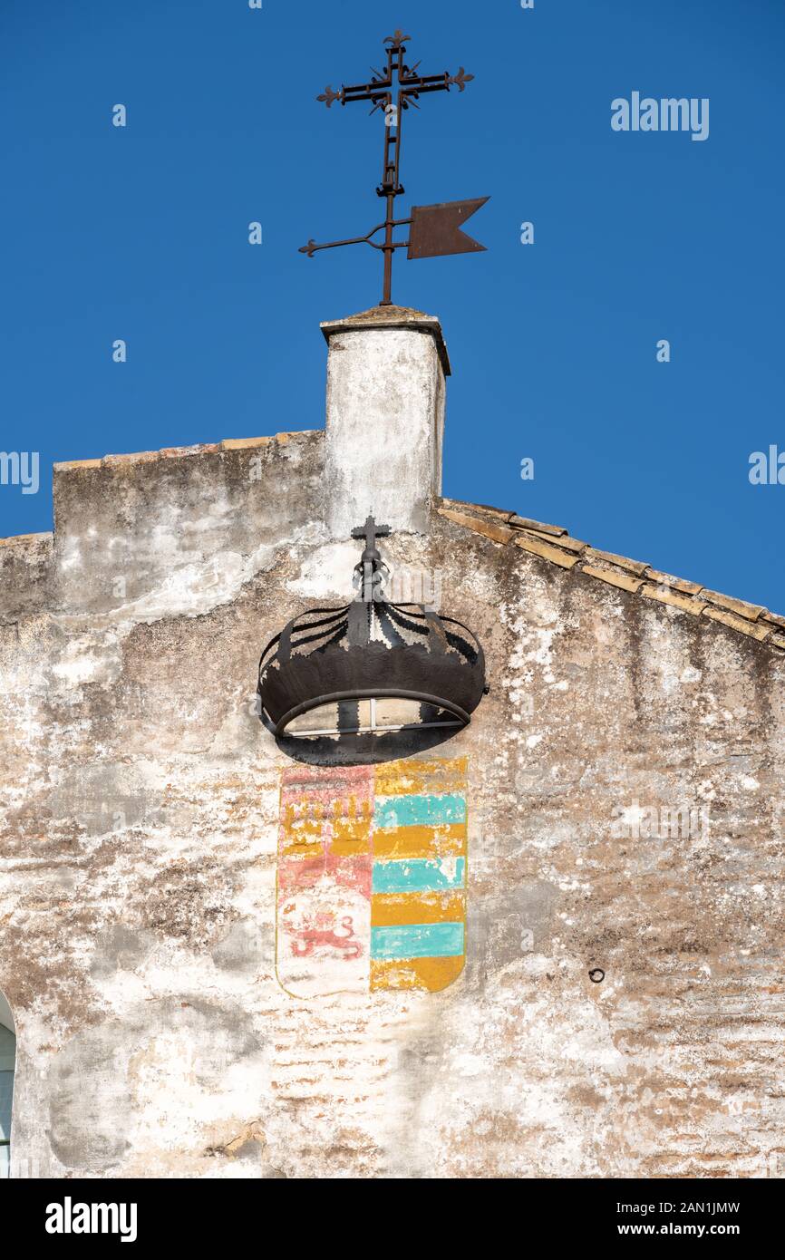 Eine schmiedeeiserne Krone, Kreuz und Wetterfahne eine Wand von der Casa de Pilatos in Sevilla schmücken. Stockfoto