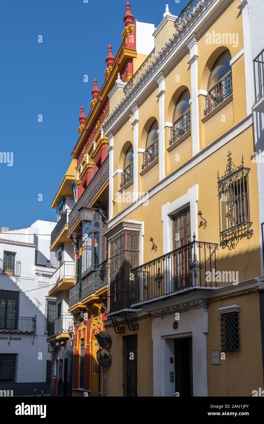 Kontrastierende farbenfrohe Gebäude in der Calle Aguilas in Santa Cruz, Sevilla Stockfoto