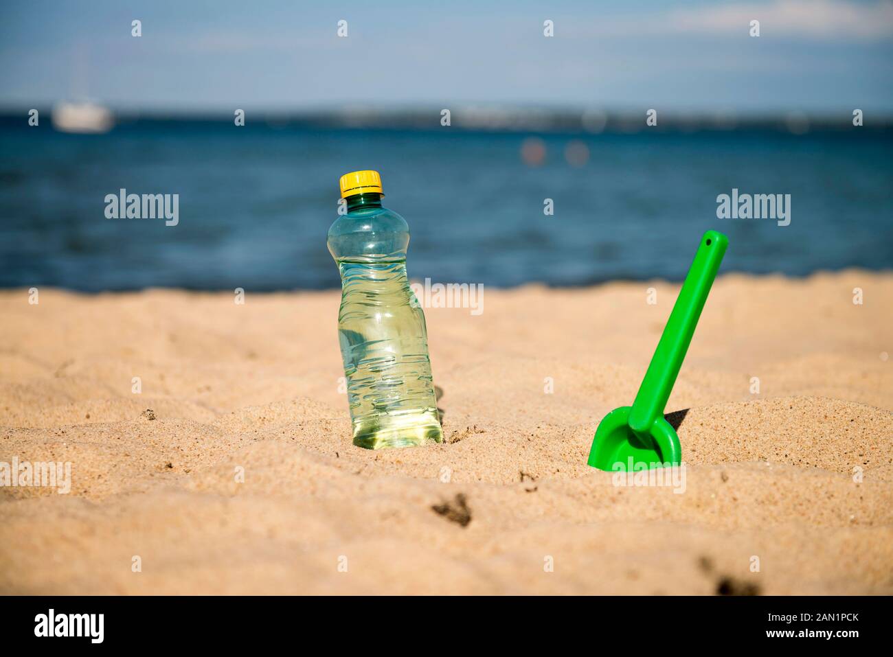 Kunststoff Flasche frisches Wasser wird auf dem Sand des Meeres. Trinkwasser in Flaschen auf Sand am Strand. Flasche frisches Wasser wird auf dem Sand des Meeres Stockfoto