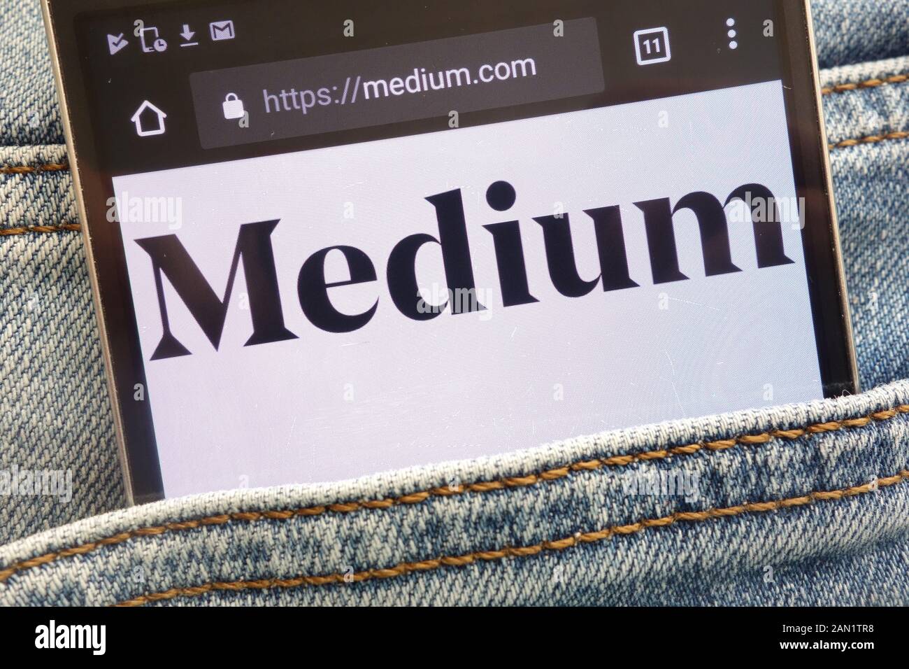 Medium Website angezeigt auf dem Smartphone in Jeans Tasche versteckt Stockfoto