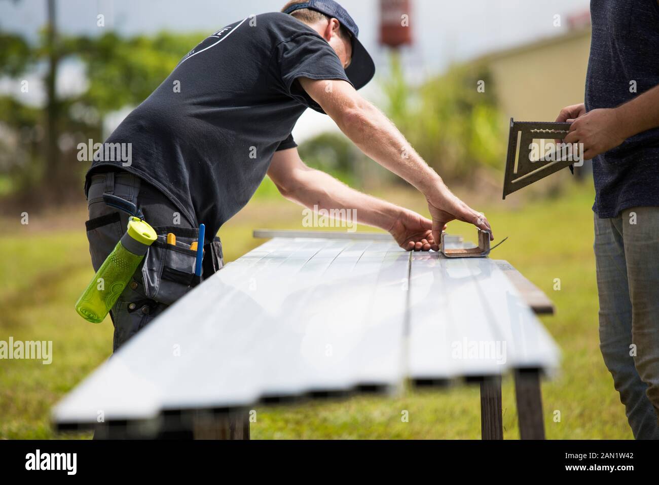 Zwei Männer messen Halterungen für die Montage von Solarpaneelen. Stockfoto
