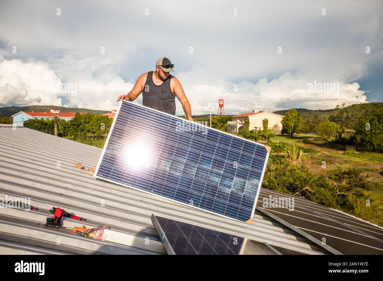 Bauarbeiter bereitet sich auf die Installation einer Solaranlage auf dem Dach vor. Stockfoto