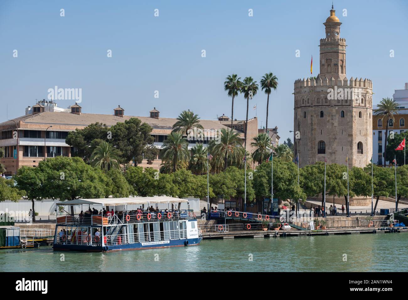 Sevillas Wachturm Torre del Oro mit Blick auf die Bootsstege am Nordufer des Flusses Guadalquivir. Stockfoto