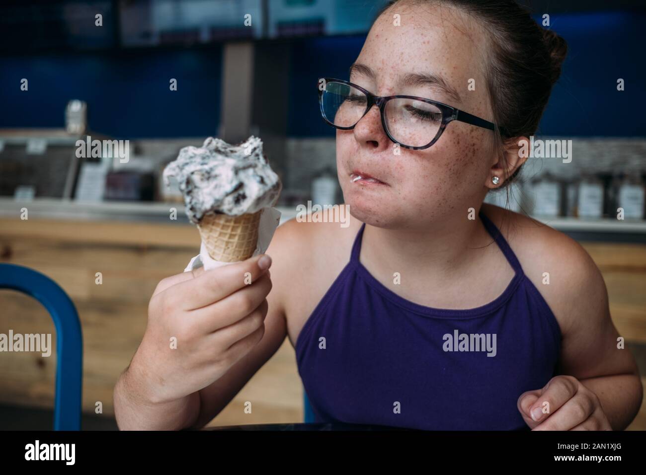 Vorderansicht von Mädchen mit Gläsern Eis essen in Eisdiele Stockfoto