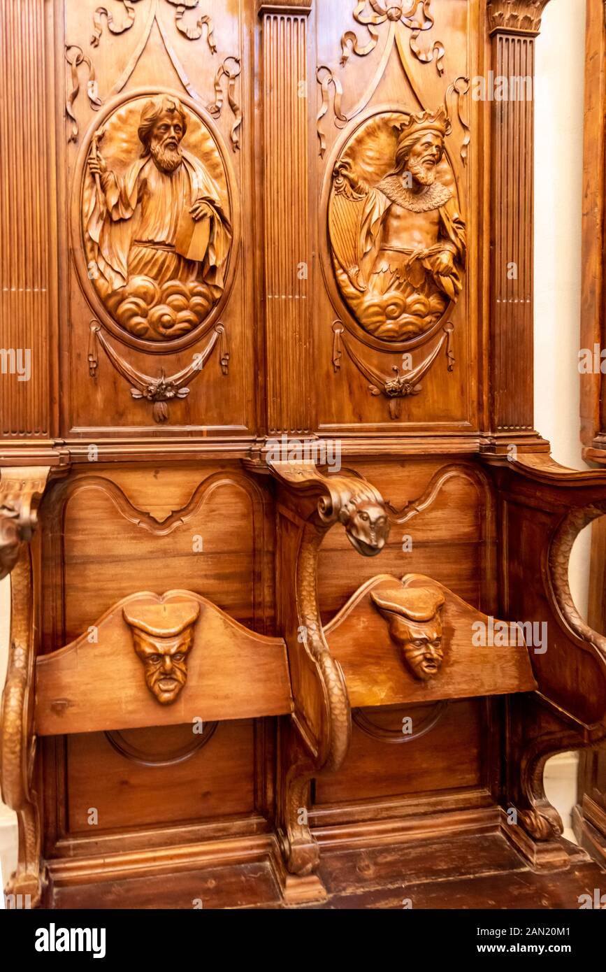 Aufwendige Schnitzereien von Männergesicht zeigen die Unterseite des Holzchorgestühls in Iglesia del Salvador in Sevilla Stockfoto