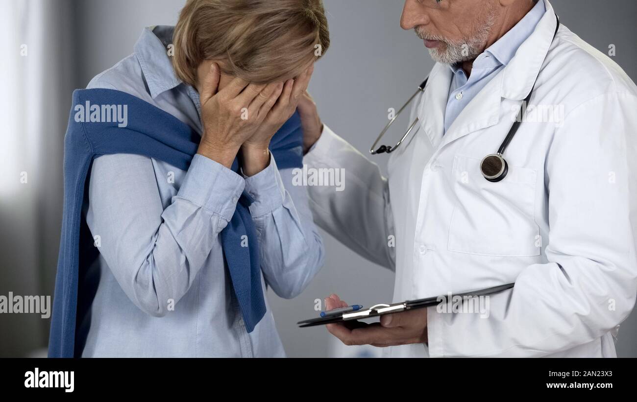 Ältere Arzt tröstet weinende Dame, schlechte Nachrichten über die Krankheit Krebs Stockfoto