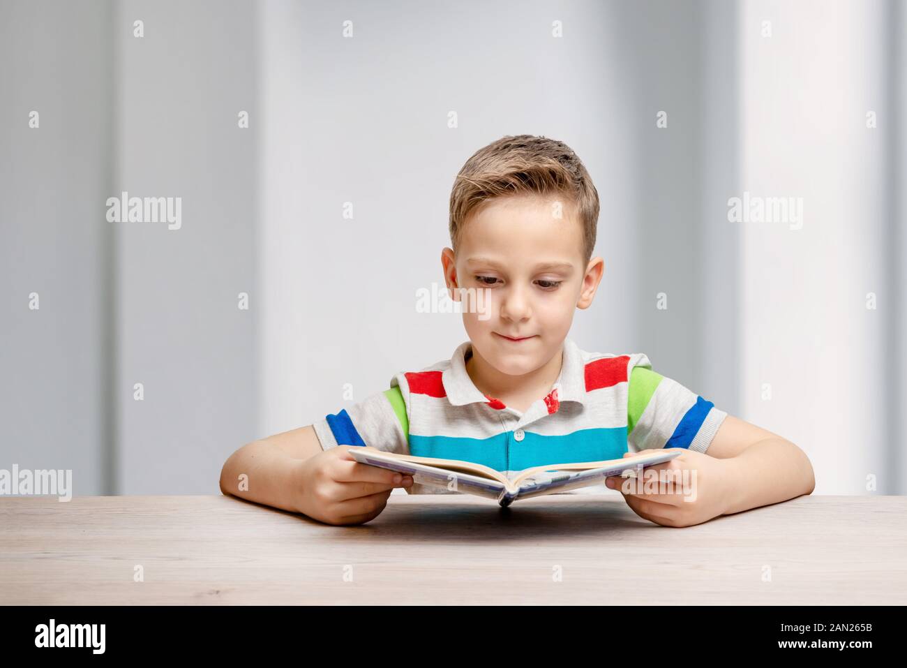 Junge hält ein offenes Buch. Konzept von Lernen und Studieren. Vorderansicht. Portrait mit Platz für Text neben Stockfoto