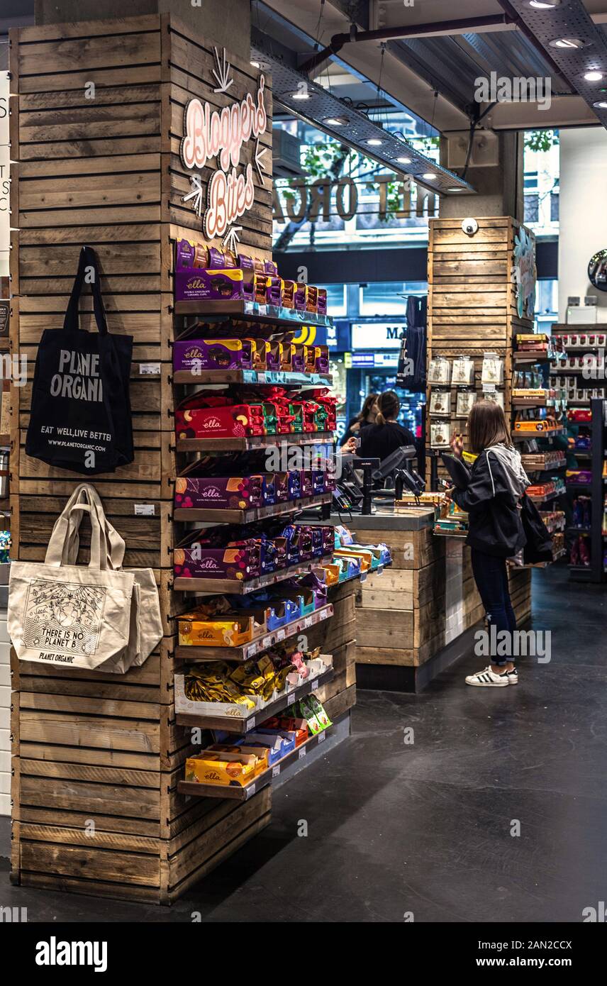 Kunden, die warten Essen im inneren Planeten Organische zu bestellen, Tottenham Court Road, London, England, UK. Stockfoto