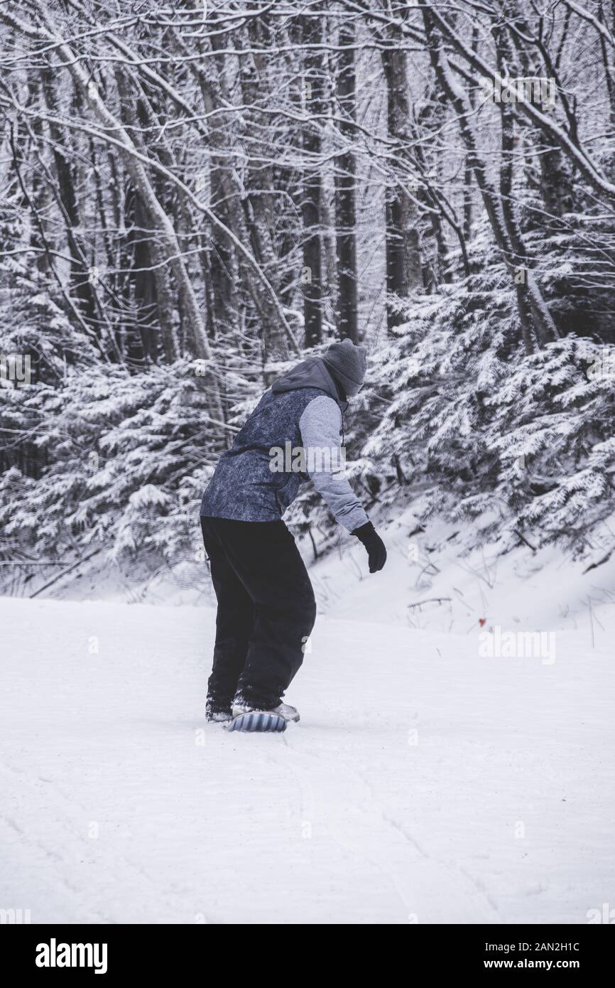 Person reiten snowskate Board in einem Winter trail Vermont State Stockfoto