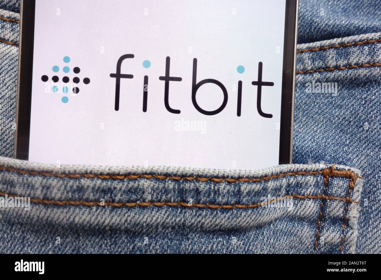 Fitbit Logo auf dem Smartphone in Jeans Tasche versteckt angezeigt Stockfoto