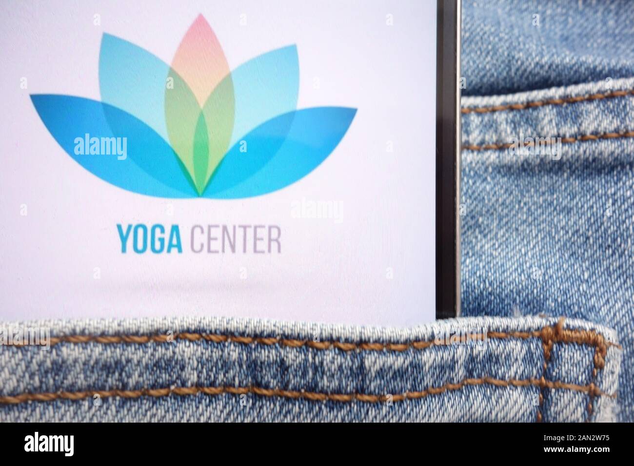 Yoga Zentrum Logo auf dem Smartphone in Jeans Tasche versteckt Stockfoto