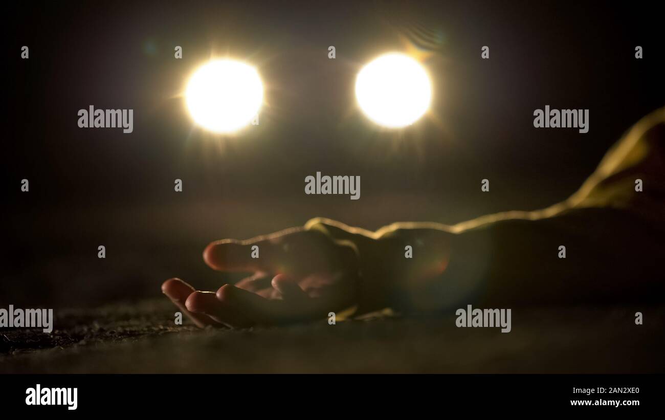 Blutige Mörder fahren auf leblosen Körper der Opfer liegen auf der Straße, schreckliche Verbrechen Stockfoto