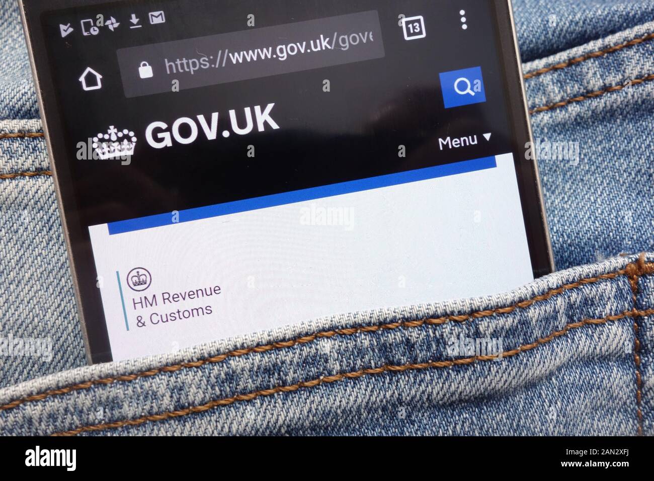 Reg. uk-Website auf dem Smartphone in Jeans Tasche versteckt angezeigt Stockfoto