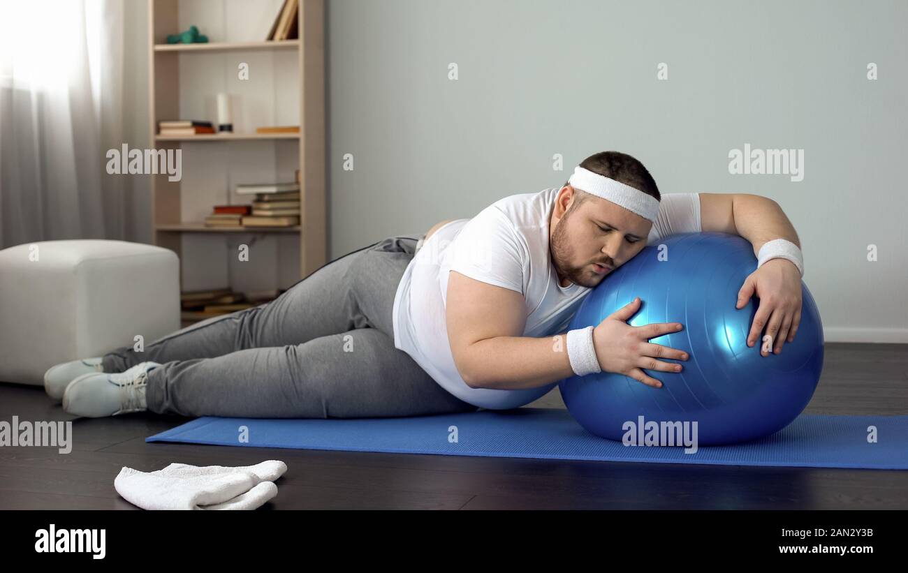 Müde unmotiviert beleibten Mann liegen auf Fitness Ball, abnehmen Fitness Programm Stockfoto