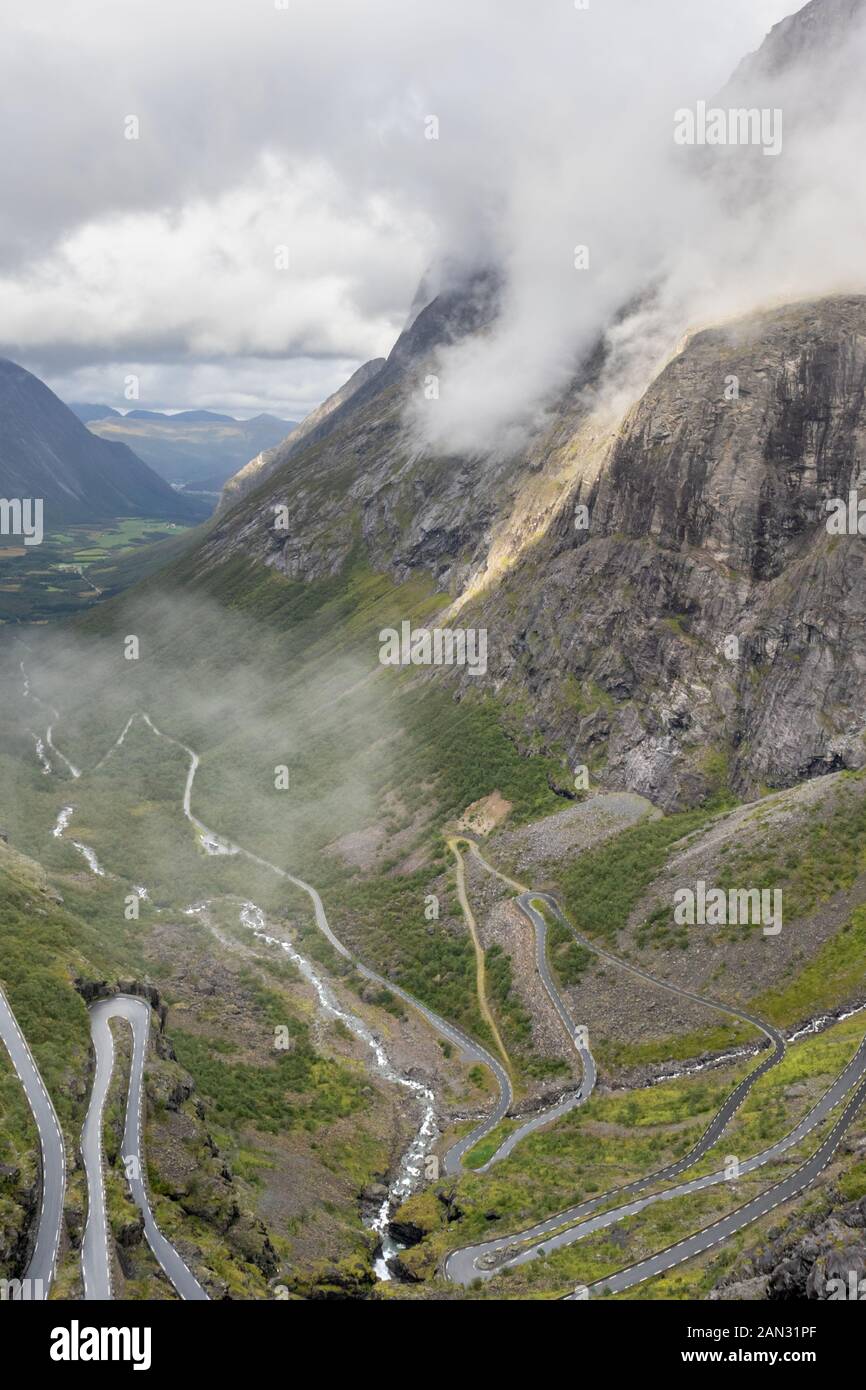 Berühmten norwegischen Berge Straße Trollstigen Blick von oben auf das Tal. Epische nordischen Natur mit Felsen, Wasserfälle, dramatische Wolken Sightseeing Tourismus, Reisen Stockfoto