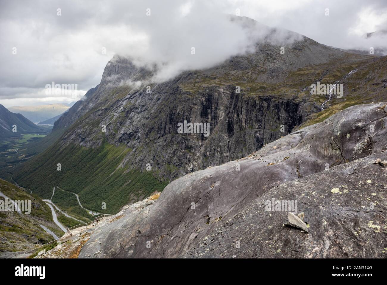 Berühmten norwegischen Berge Straße Trollstigen. Blick von oben auf das Tal von großen grauen Rock. Nordic Natur mit Felsen dramatische Wolken. Stockfoto