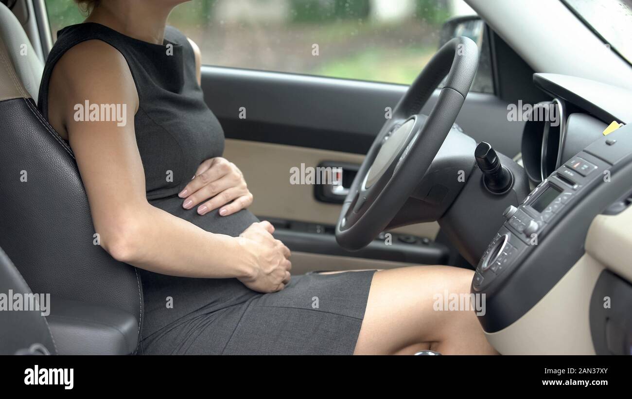 Schwangere Frau sitzt im Auto und berührt, Magen, über Baby Pflege  Stockfotografie - Alamy