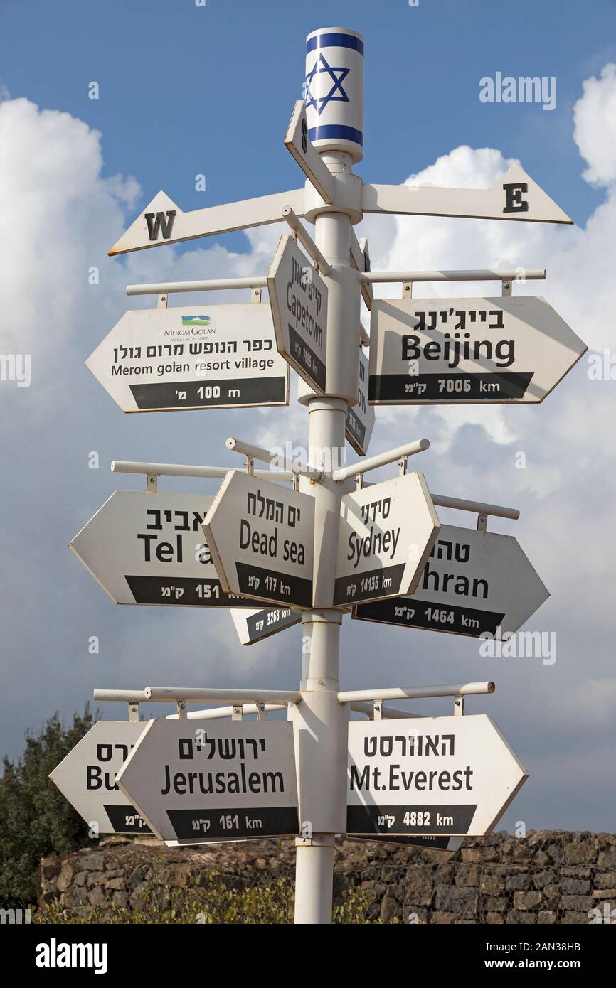 Wegweiser auf Hebräisch und Englisch mit Pfeilen, die auf Orte rund um die Welt zeigen, vom Merom Golan Resort Village, Israel Stockfoto