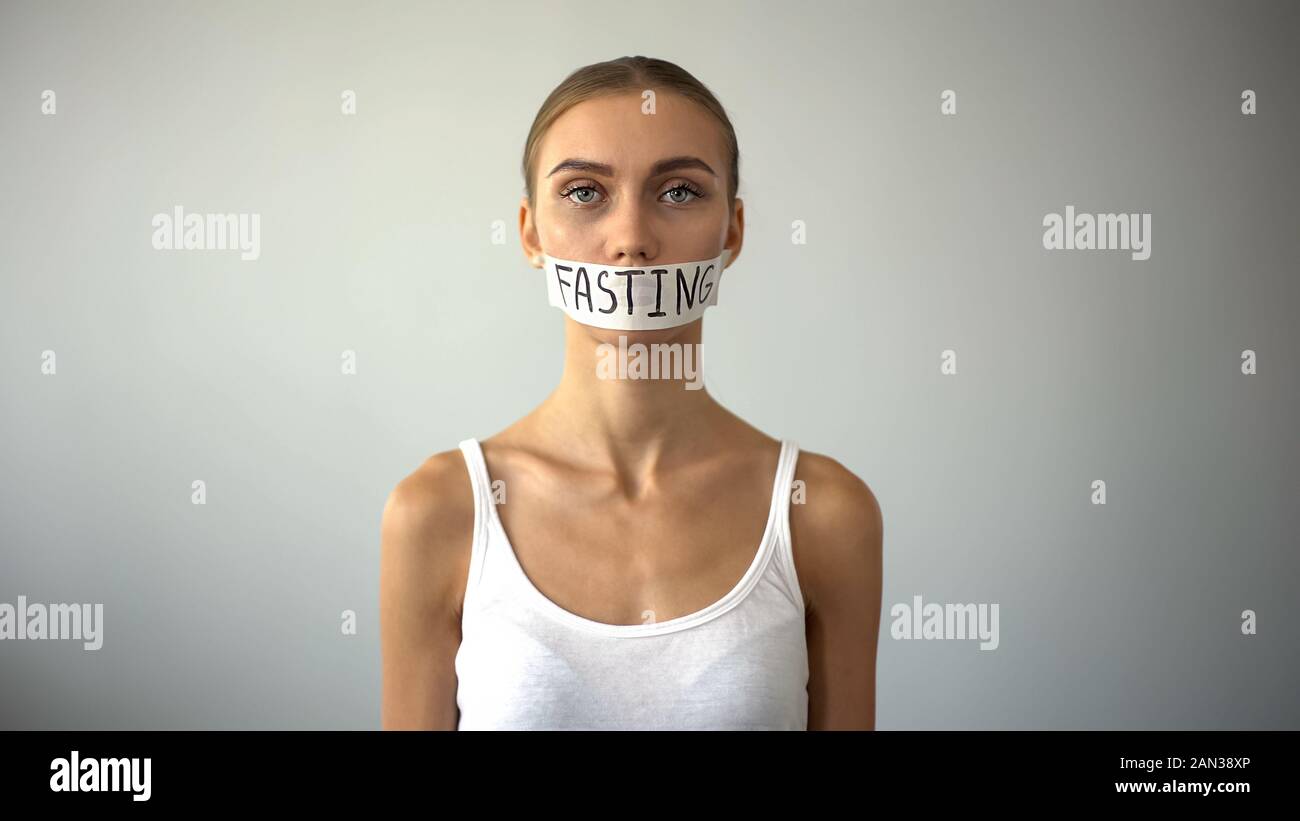 Fasten Wort auf Klebeband Mund umgekippt magersüchtig Modell geschrieben, Selbstzerstörung Stockfoto