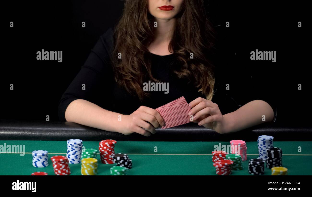 Weibliche Spieler verlieren Poker Runde umgekippt, schlechte Hand, Casino Chips am Tisch rund Stockfoto