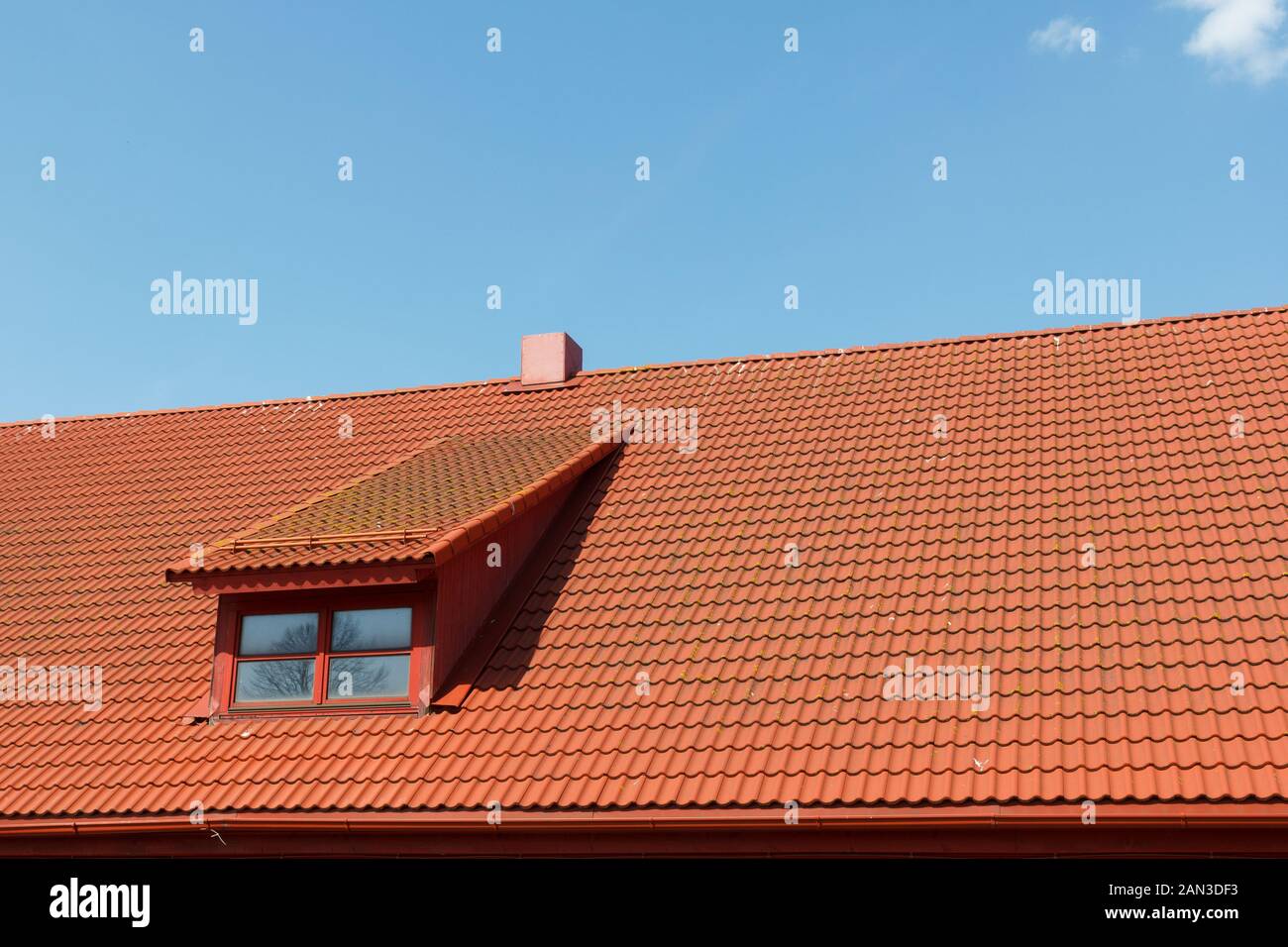 Rotes Ziegeldach mit Fenster und Schornstein Stockfoto