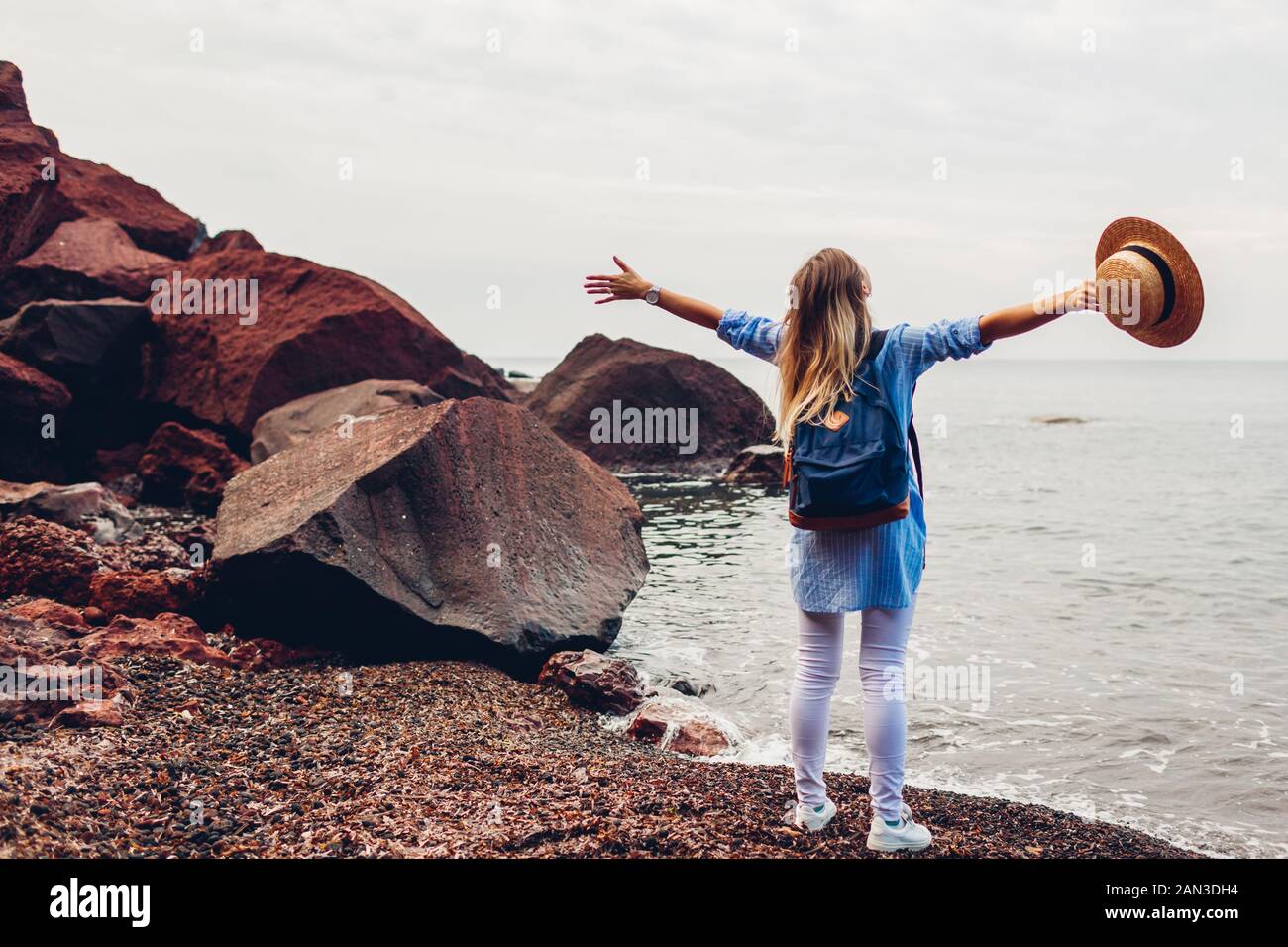 Frau Reisenden zu Fuß erhobenen Arme Gefühl glücklich am Red Beach in Insel Santorini, Griechenland. Tourismus, Reisen Stockfoto