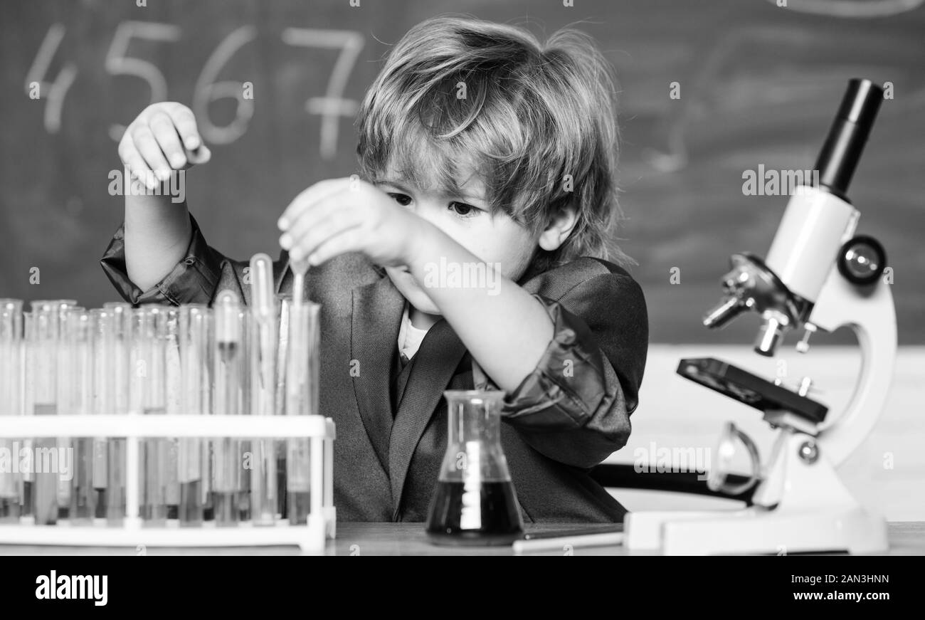 Begabtes Kind und Wunderkind. Kid Chemie Schule. Schule Bildung. Biologische Moleküle erkunden. Kleinkind genius Baby. Junge in der Nähe von Mikroskop und Reagenzgläser in der Schule Klassenzimmer. Wissenschaft Konzept. Stockfoto