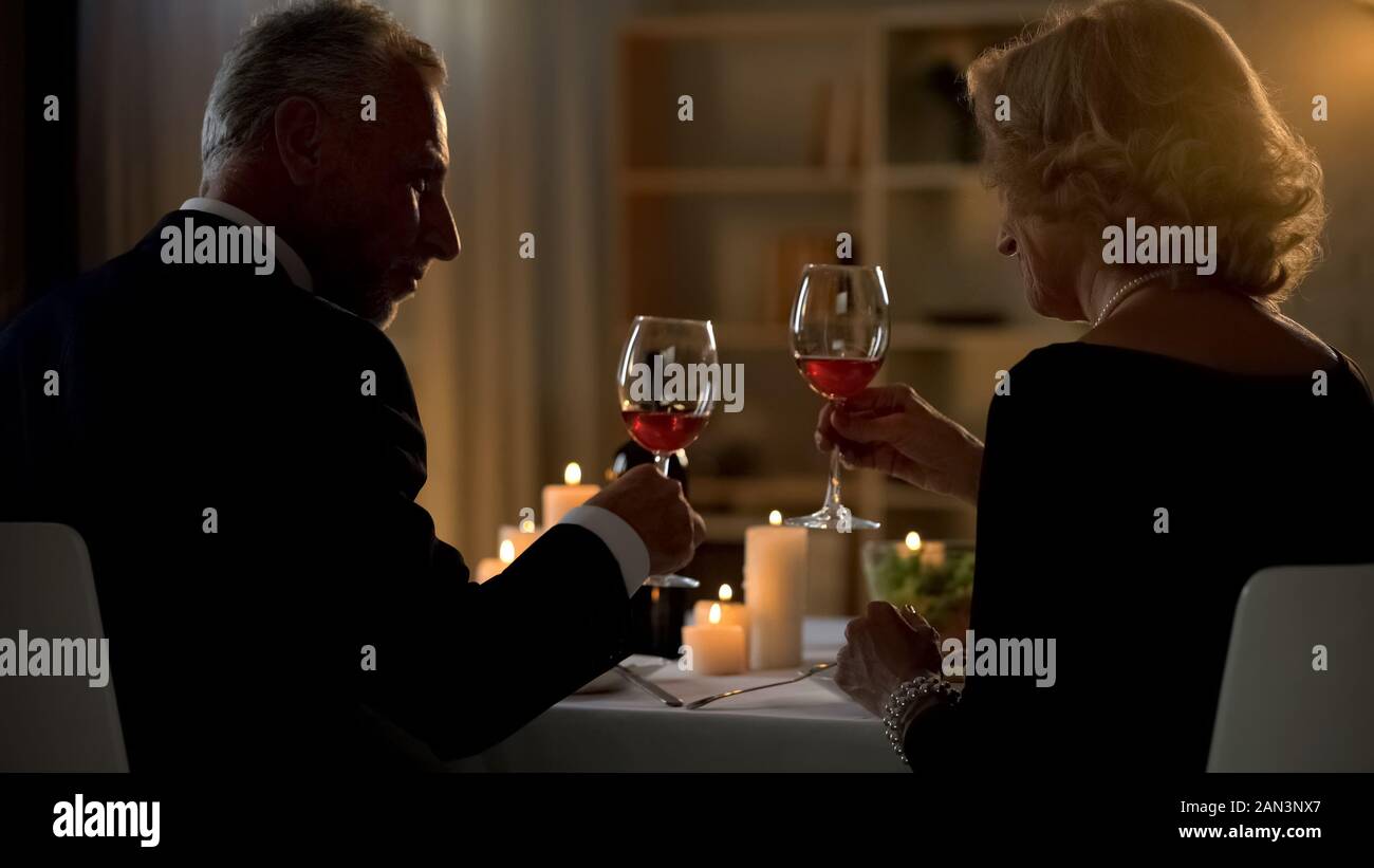 Eleganten Mann und Frau mit Rotwein Gläser, Senior Paar auf Datum, Liebe Stockfoto
