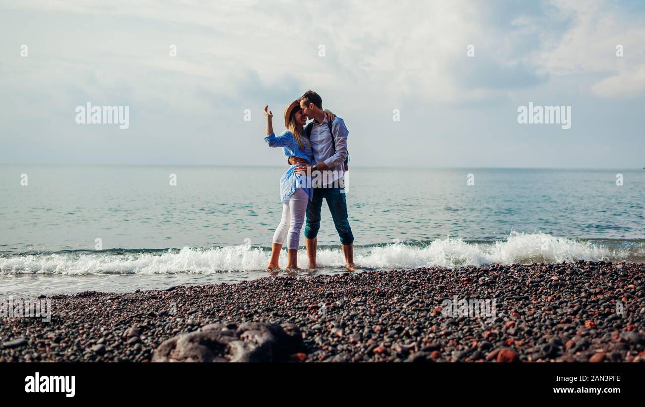 Valentines Tag. Verliebtes Paar auf Hochzeitsreise in Santorin, Griechenland zu küssen. Menschen zu Fuß am Strand von Meer. Stockfoto