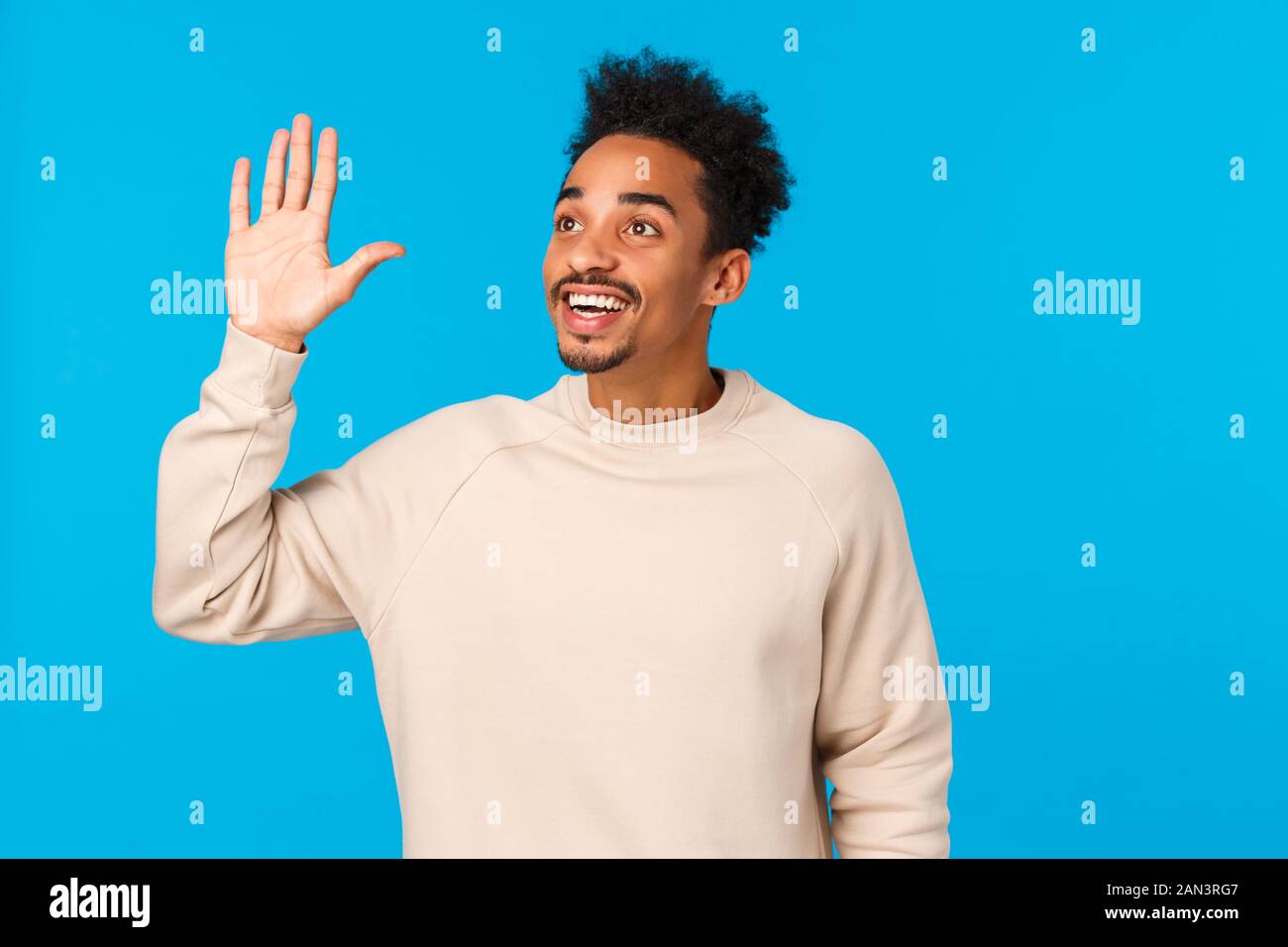 Hey hallo, hier. Attraktive freundlich african-american hipster Kerl afro Frisur, Schnurrbart, sehen Freund in Masse, linke obere Ecke Stockfoto