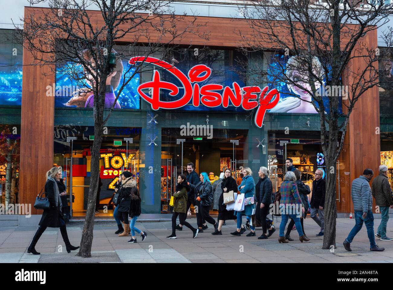 Die Einzelhändler der Oxford Street in London gehen an der farbenfrohen Fassade des Disney Toy Store in der Oxford Street, London, vorbei Stockfoto