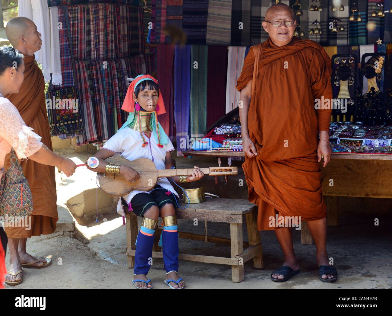 Eine Padaung Frau spielen ein traditionelles Saiteninstrument. Stockfoto