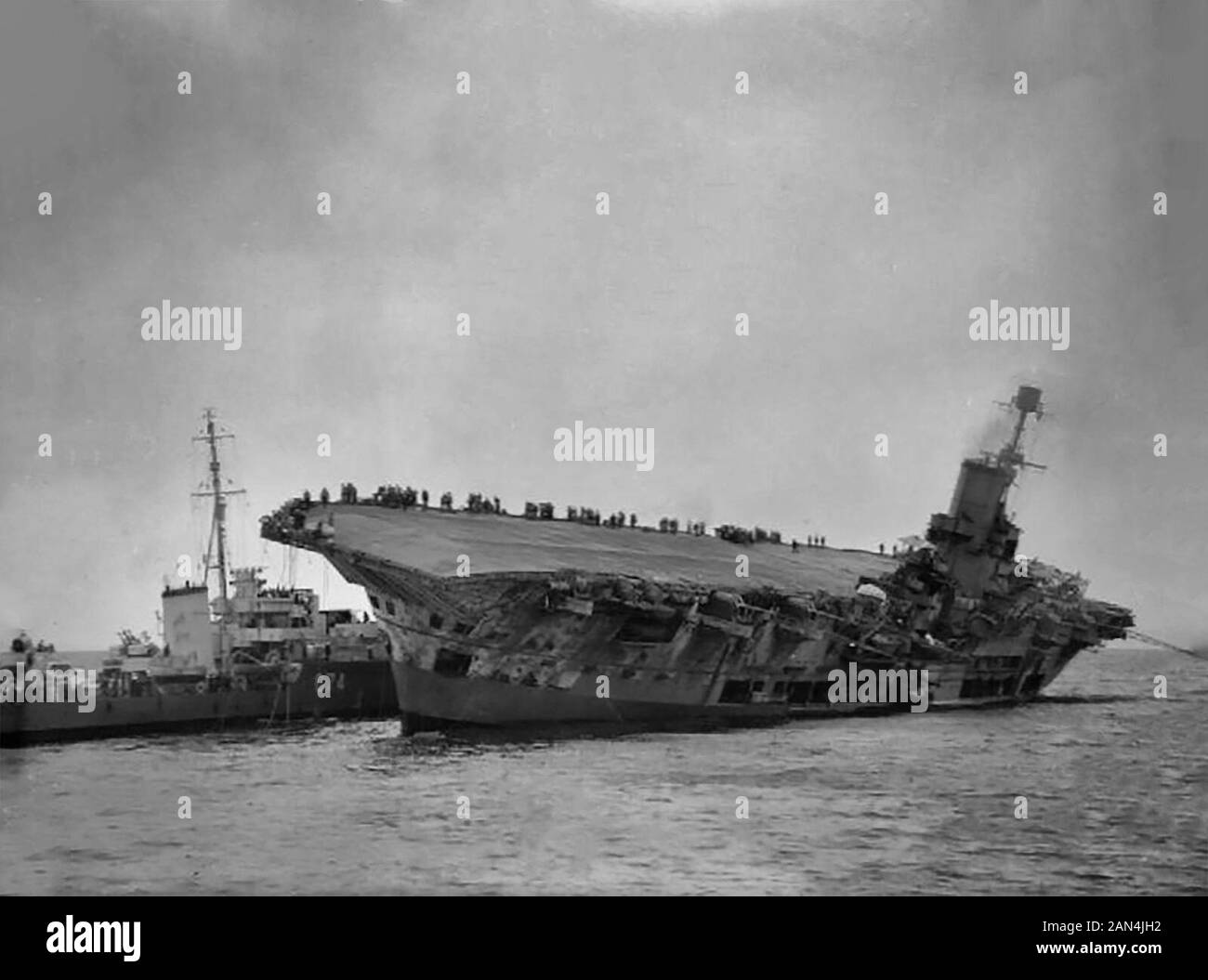 Die "HMS Legion" bewegt sich neben der beschädigten und auflistenden "HMS Ark Royal", um Überlebende abzuziehen. Der Flugzeugträger wurde von dem deutschen U-Boot U 81 vor Gibraltar torpediert. Die "HMS Ark Royal" sank am folgenden Tag. November 1941 Stockfoto