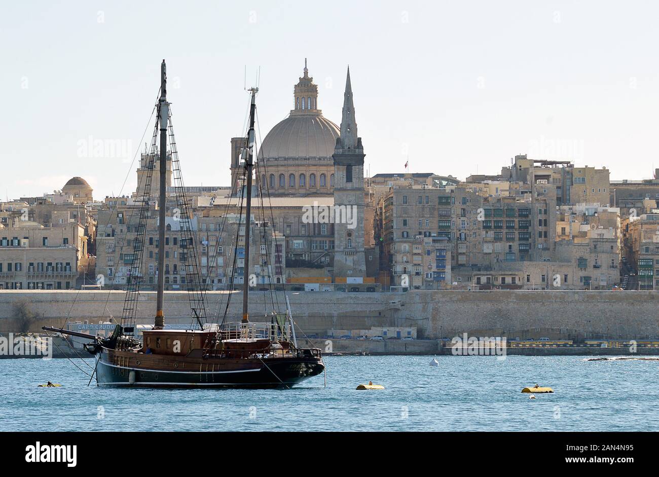 Valletta, MALTA - 10. JANUAR 2020: Ein Schoner, der im Hafen von Marsamxetto zwischen Sliema und Valletta mit dem Turm der anglikanischen Kathedrale von St Paul gegraben wurde Stockfoto