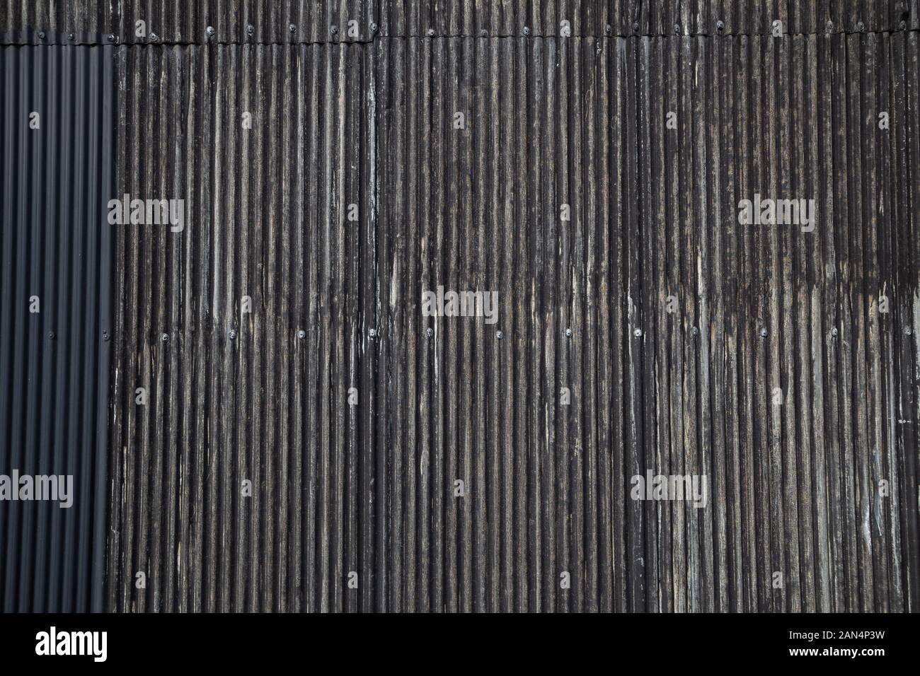 Schwarze Farbe alten rostigen gewelltes Blech Wand Hintergrund Stockfoto