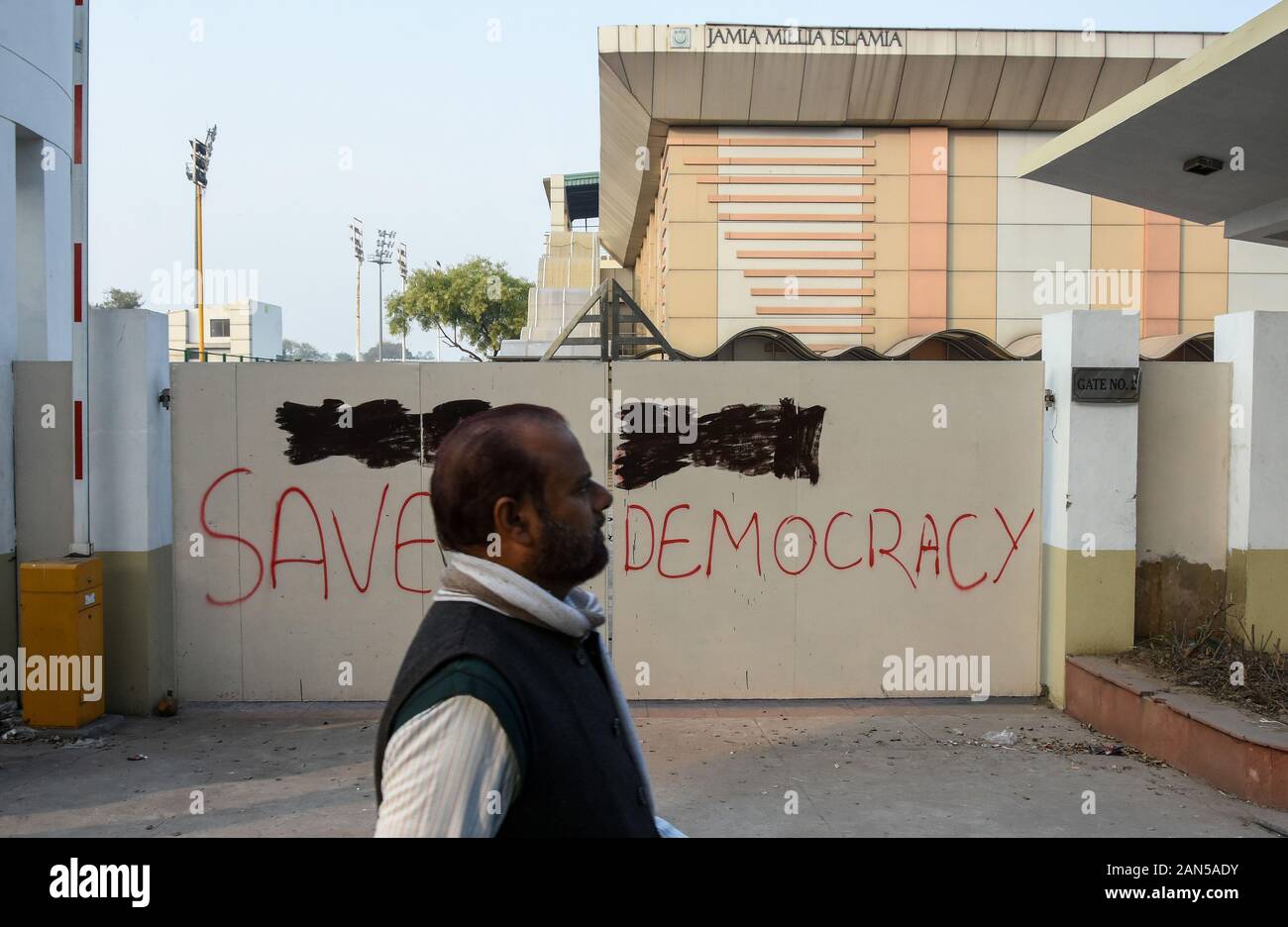 Ein Mann hinter einer Wand auf Demokratie speichern während eines Protestes gegen die Bürgerschaft Amendment Act (KAB) und der Bürger (NRC) an der Jamia Millia Islamia University geschrieben. Stockfoto