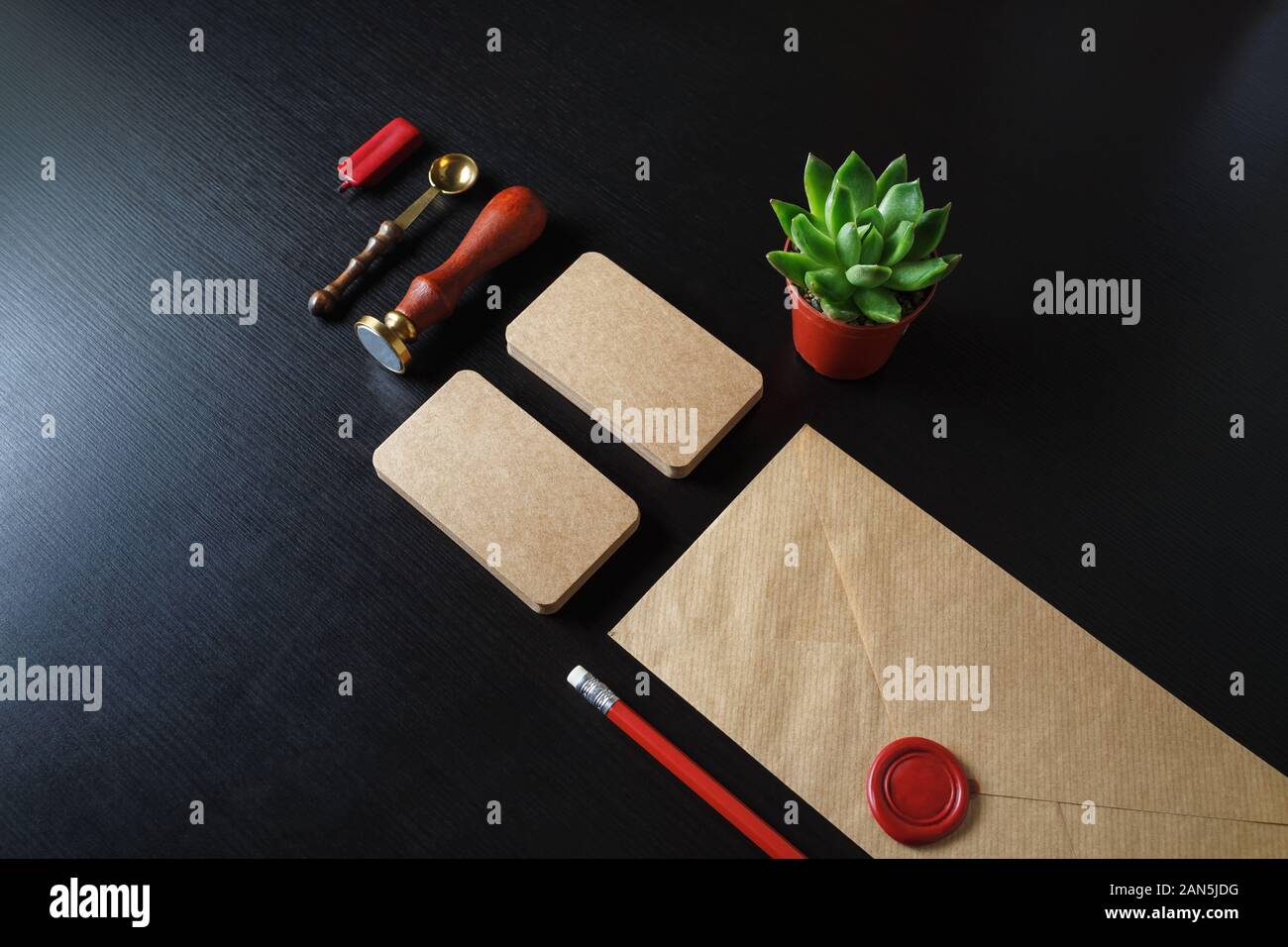Kraftpapier branding Schreibwaren auf schwarzem Holz Tabelle hinterlegt. Leere Corporate ID Vorlage. Stockfoto
